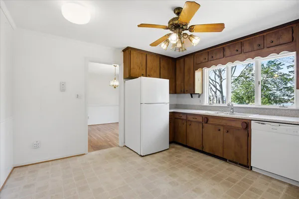 a kitchen with stainless steel appliances kitchen island granite countertop a refrigerator and a sink