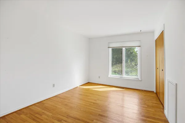 an empty room with windows and fireplace