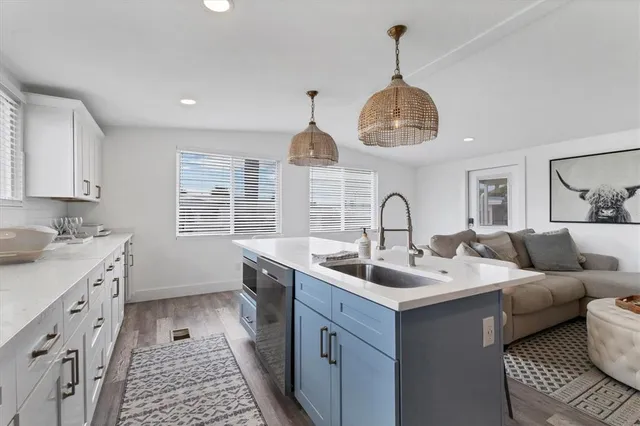 a kitchen with a sink and a stove with wooden floor