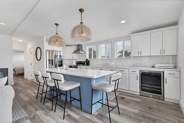 a kitchen with stainless steel appliances a dining table chairs stove and sink