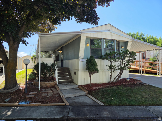 1111 North 2000 West, Unit 147 Ogden, UT 84404 - Photo 1 of 12 Light-colored siding exterior with a front entry porch featuring steps and a side ramp