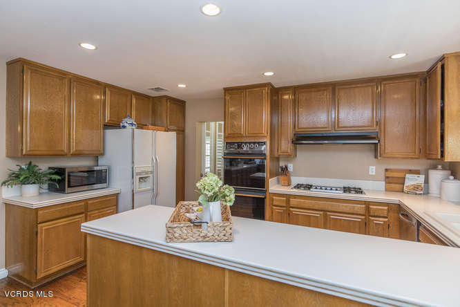 12440 Crystal Ranch Road Moorpark, CA 93021 - Photo 17 of 51 a kitchen with kitchen island stainless steel appliances a sink a stove a refrigerator cabinets and a counter top space