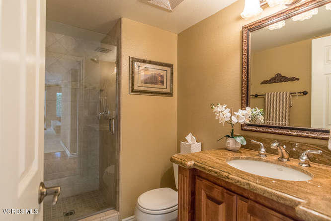12440 Crystal Ranch Road Moorpark, CA 93021 - Photo 27 of 51 a bathroom with a granite countertop sink toilet a mirror and shower