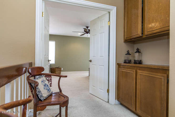 12440 Crystal Ranch Road Moorpark, CA 93021 - Photo 31 of 51 a hallway with furniture and wooden cabinets