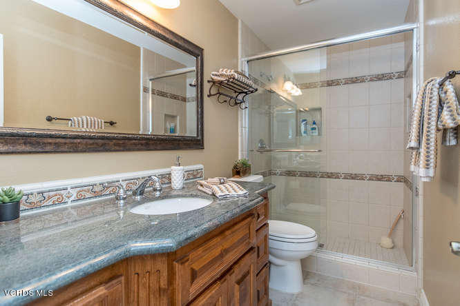 12440 Crystal Ranch Road Moorpark, CA 93021 - Photo 41 of 51 a bathroom with a granite countertop sink toilet a mirror and shower