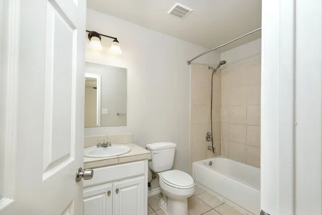 a bathroom with a granite countertop sink a toilet and shower