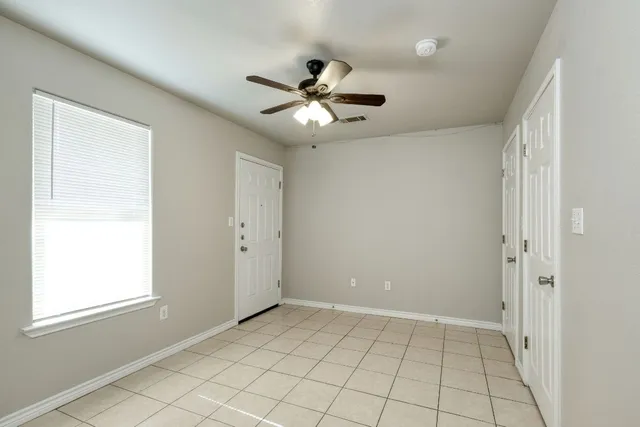 a view of an empty room and window chandelier fan