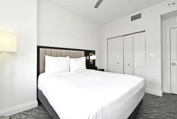 a large bed in a bedroom next to a cabinet