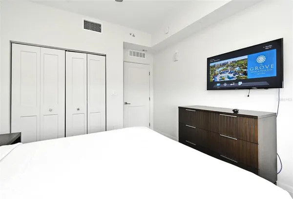 a bedroom with a bed and a flat screen tv
