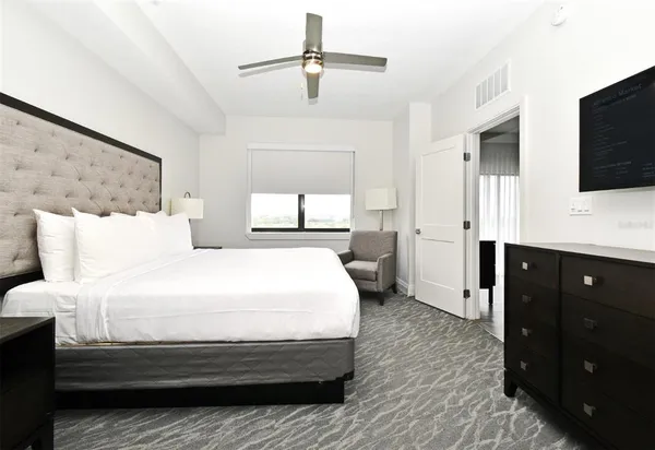 a bedroom with bed tv and window