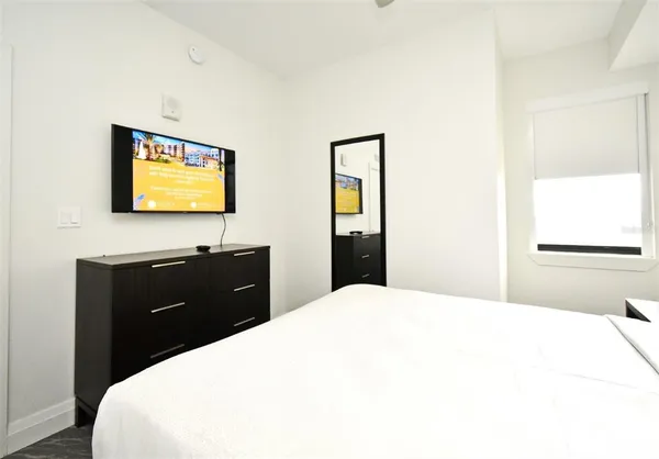 a bedroom with a bed and a flat screen tv