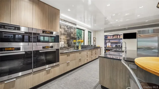 a large kitchen with stainless steel appliances granite countertop a stove refrigerator and a sink