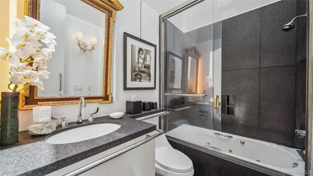 a bathroom with a toilet sink and mirror