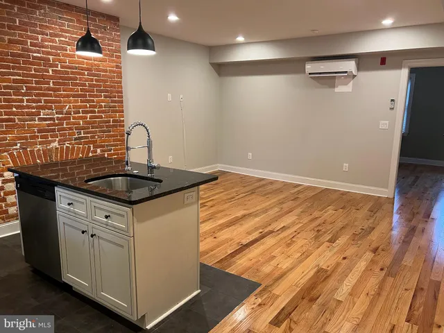 a kitchen that has a sink a stove and a wooden floors