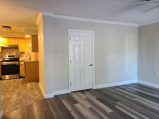 a view of empty room with wooden floor