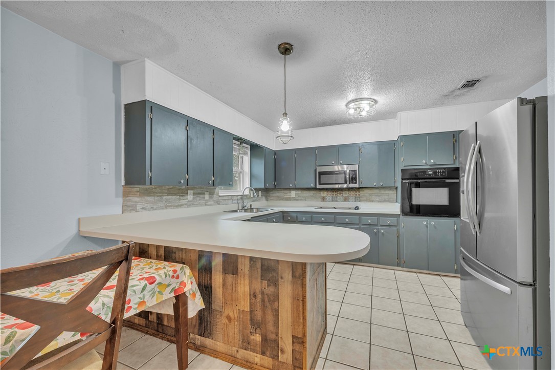 806 County Road 4756 Kempner, TX 76539 - Photo 11 of 33 a kitchen with stainless steel appliances granite countertop a sink and a refrigerator