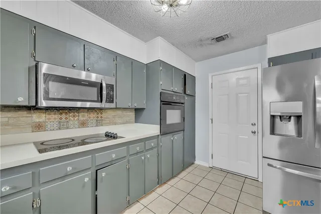 a view of a kitchen with a sink and refrigerator
