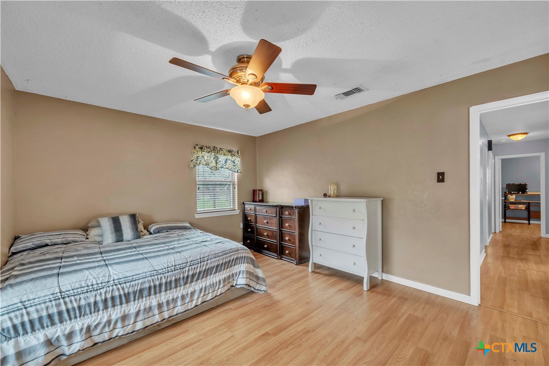806 County Road 4756 Kempner, TX 76539 - Photo 19 of 33 a bedroom with a large bed and a chandelier