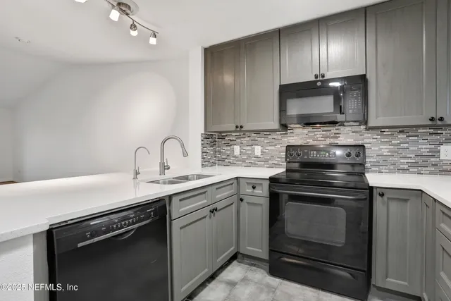 a view of a livingroom with a ceiling fan wooden floor and kitchen