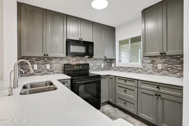 an empty room with wooden floor ceiling fan and windows