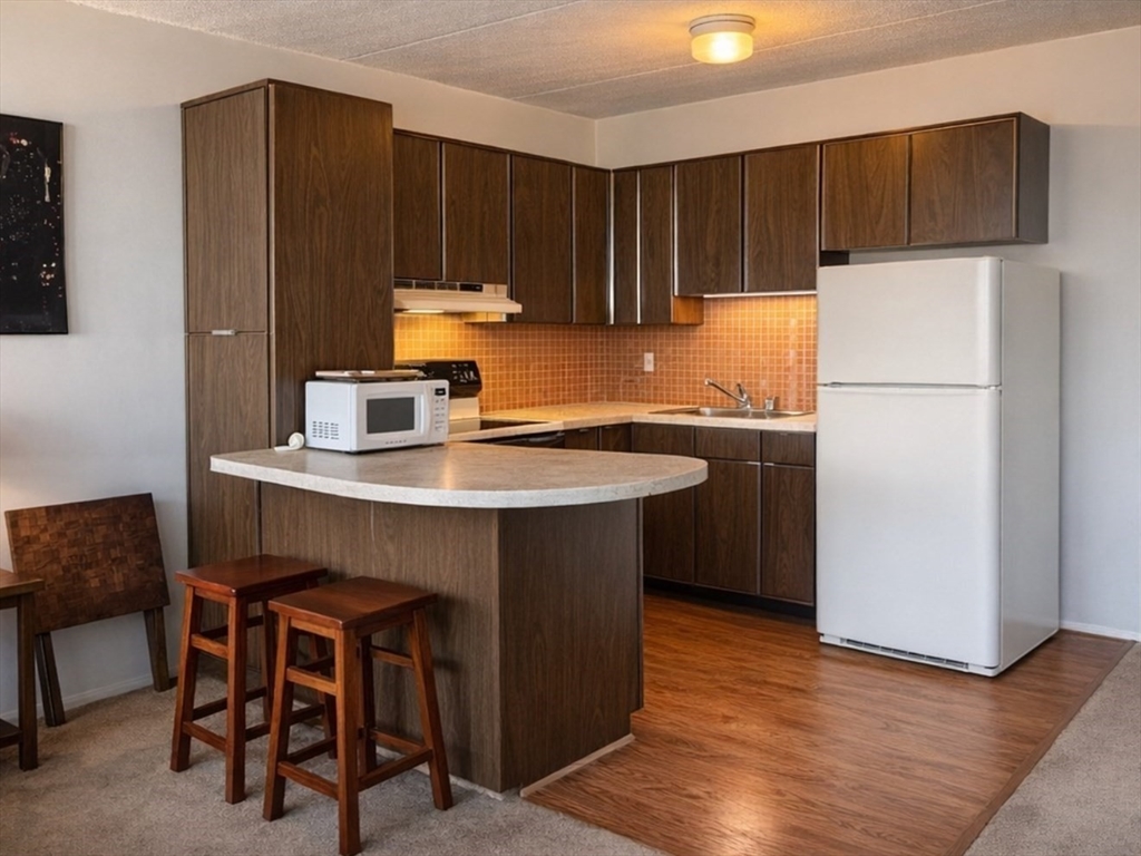 a kitchen with a sink cabinets and wooden floor