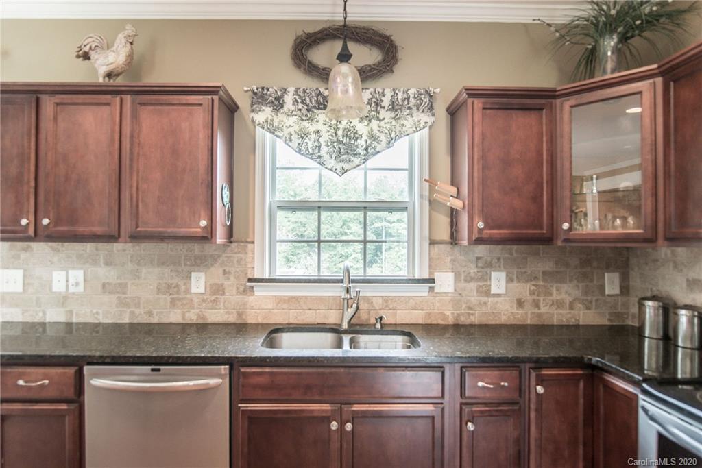 725 Hawley Road McConnells, SC 29726 - Photo 8 of 32 a kitchen with stainless steel appliances granite countertop a sink a stove with wooden cabinets and a window