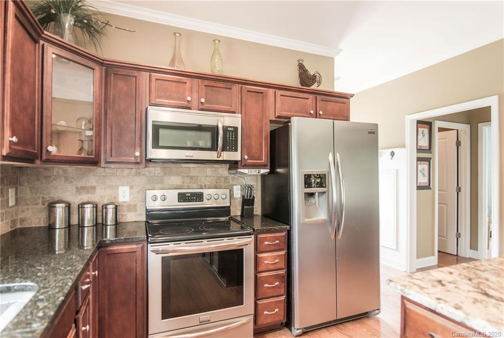 725 Hawley Road McConnells, SC 29726 - Photo 9 of 32 a kitchen with stainless steel appliances granite countertop a refrigerator a stove and a sink with wooden floor