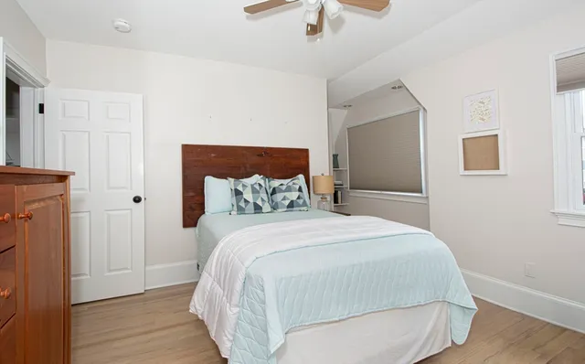 a bedroom with bed and wooden floor