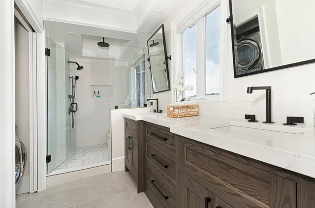 a bathroom with a double vanity sink mirror and shower