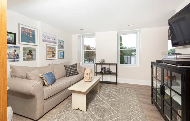 a living room with furniture a flat screen tv and a window
