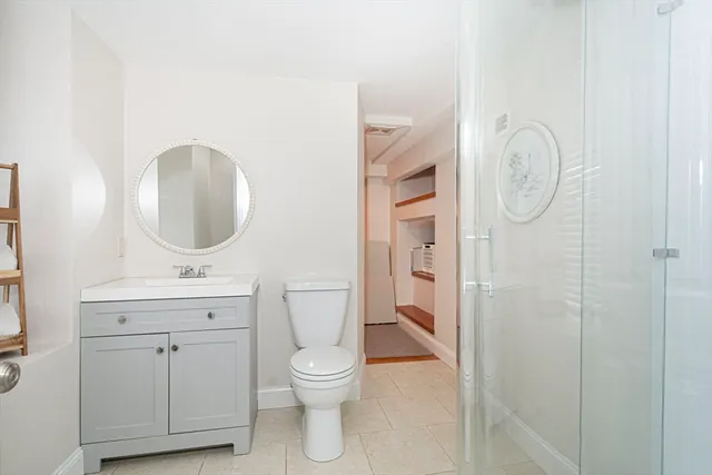 a bathroom with a toilet a sink and mirror
