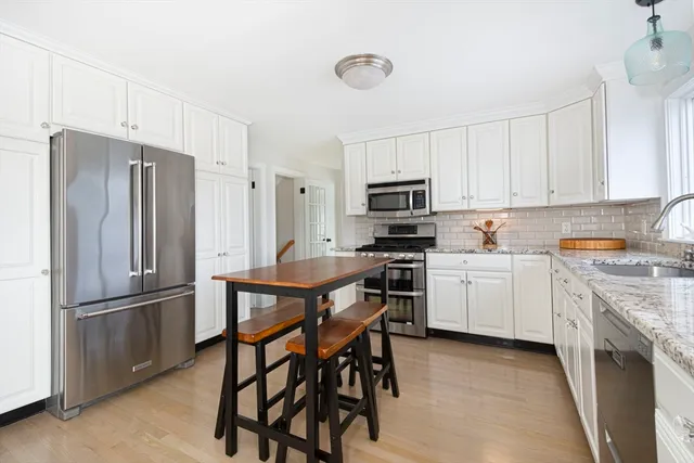 a kitchen with white cabinets stainless steel appliances and a refrigerator