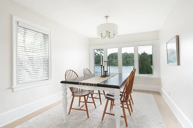 a dining room with furniture a rug and a large window