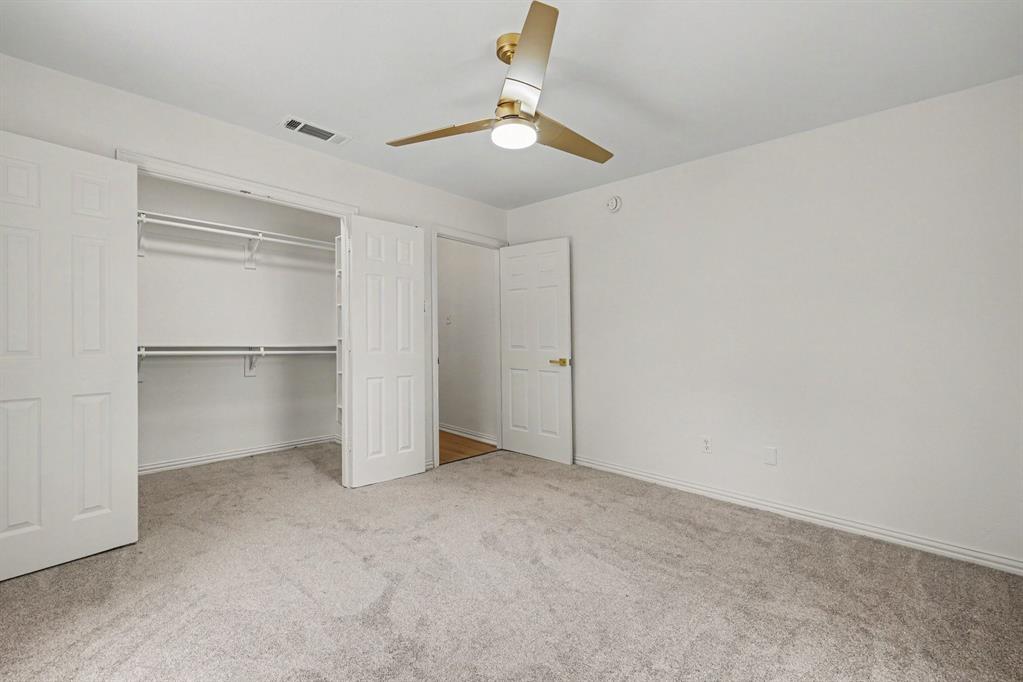 307 Dixon Street Terrell, TX 75160 - Photo 24 of 32 Bedroom featuring light gray carpeting, a built-in closet with bifold doors, and an overhead ceiling fan with integrated lighting