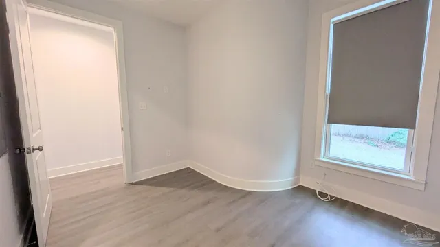 an empty room with wooden floor and cabinet