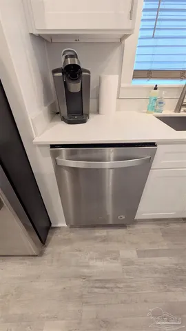 a kitchen with stainless steel appliances a refrigerator a sink a stove and white cabinets