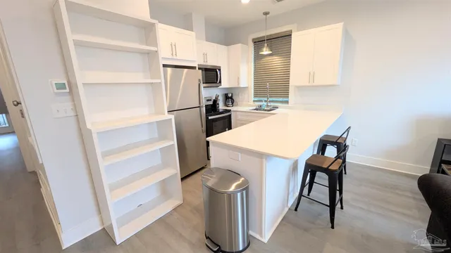 a kitchen with a refrigerator and white cabinets