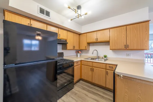 a kitchen with stainless steel appliances granite countertop a sink a stove and a refrigerator
