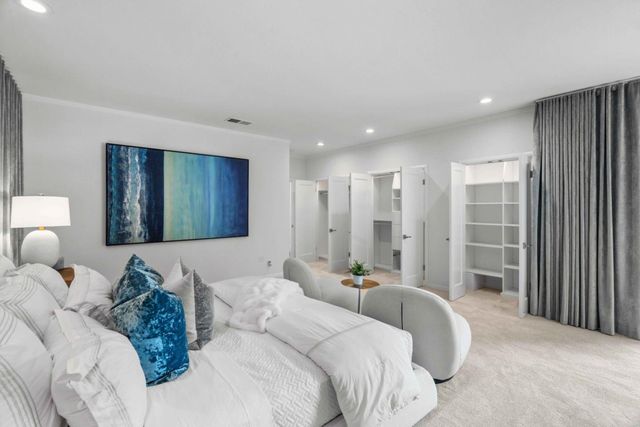 a bedroom with a large bed and a chandelier