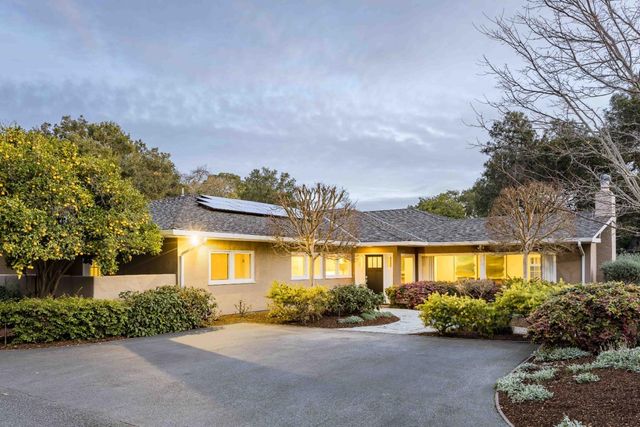 a front view of a house with a garden