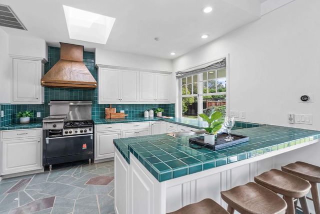 a kitchen with kitchen island granite countertop a stove a sink and a granite counter tops