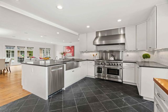 a kitchen with kitchen island granite countertop a sink a counter top space stainless steel appliances and cabinets