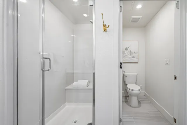 a bathroom with a toilet and a shower