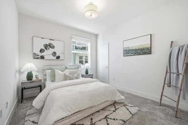 a bedroom with a bed and a painting on the wall