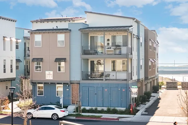 a front view of a residential apartment building with a car parked