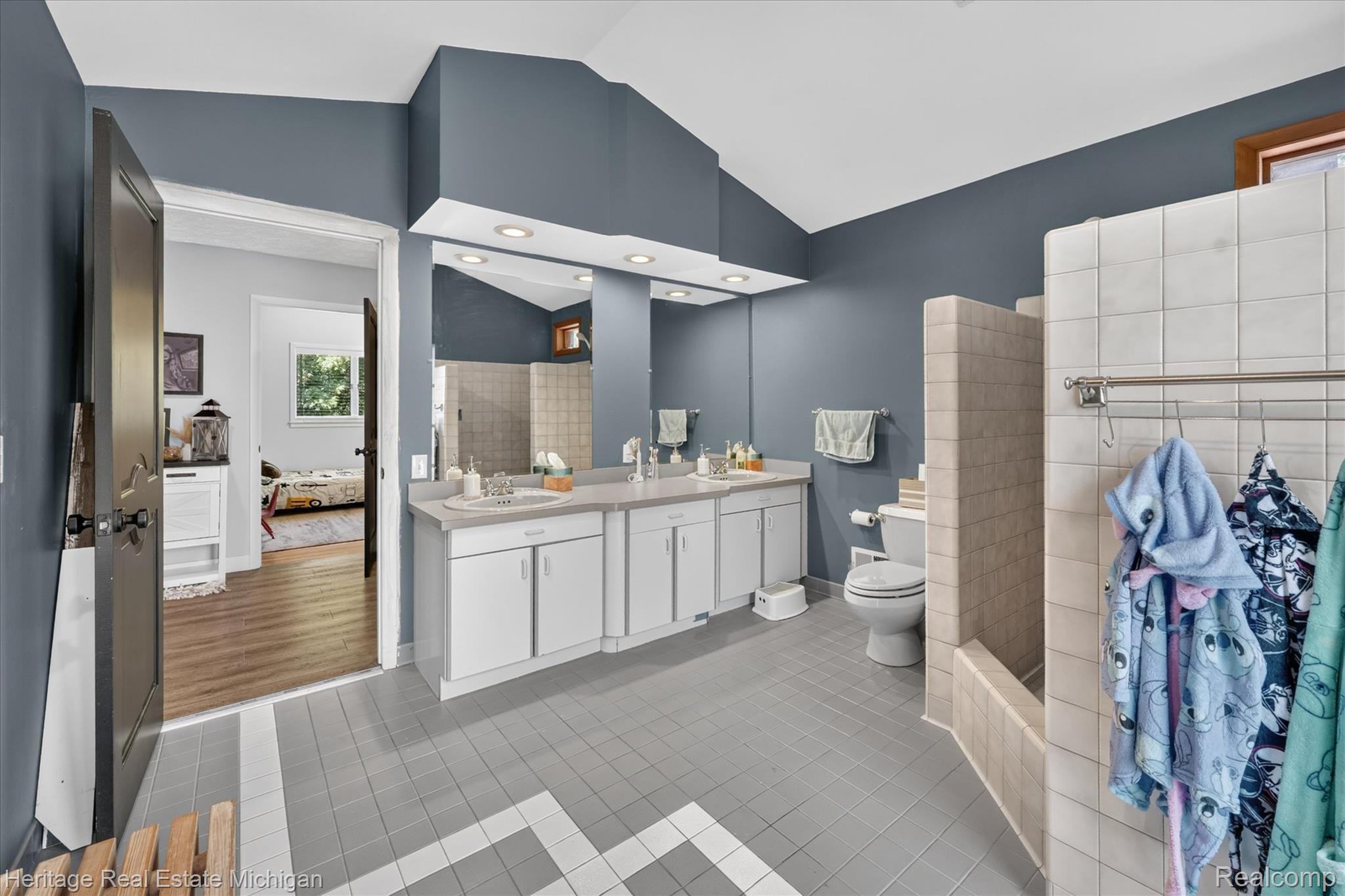 1888 Germany Road Williamston, MI 48895 - Photo 24 of 57 Bathroom featuring a double vanity with ample counter space, recessed lighting, tile flooring, and a tiled shower enclosure