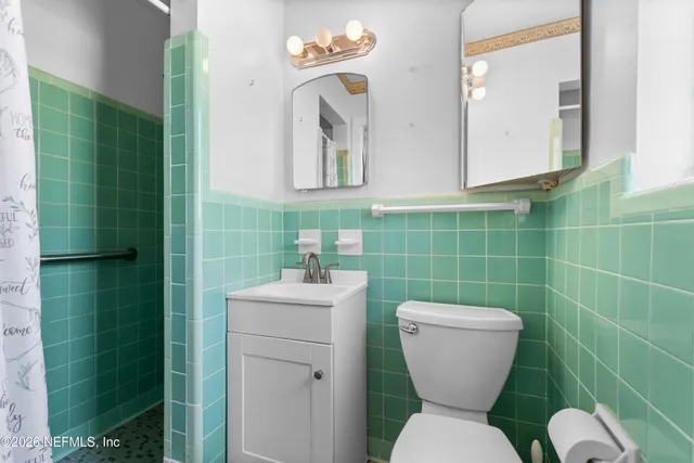 a bathroom with a toilet sink and mirror