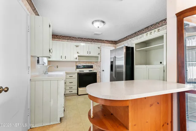 a kitchen with stainless steel appliances a stove a sink refrigerator and a refrigerator