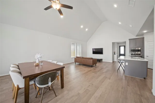 a living room with stainless steel appliances kitchen island granite countertop furniture a large window and a kitchen view
