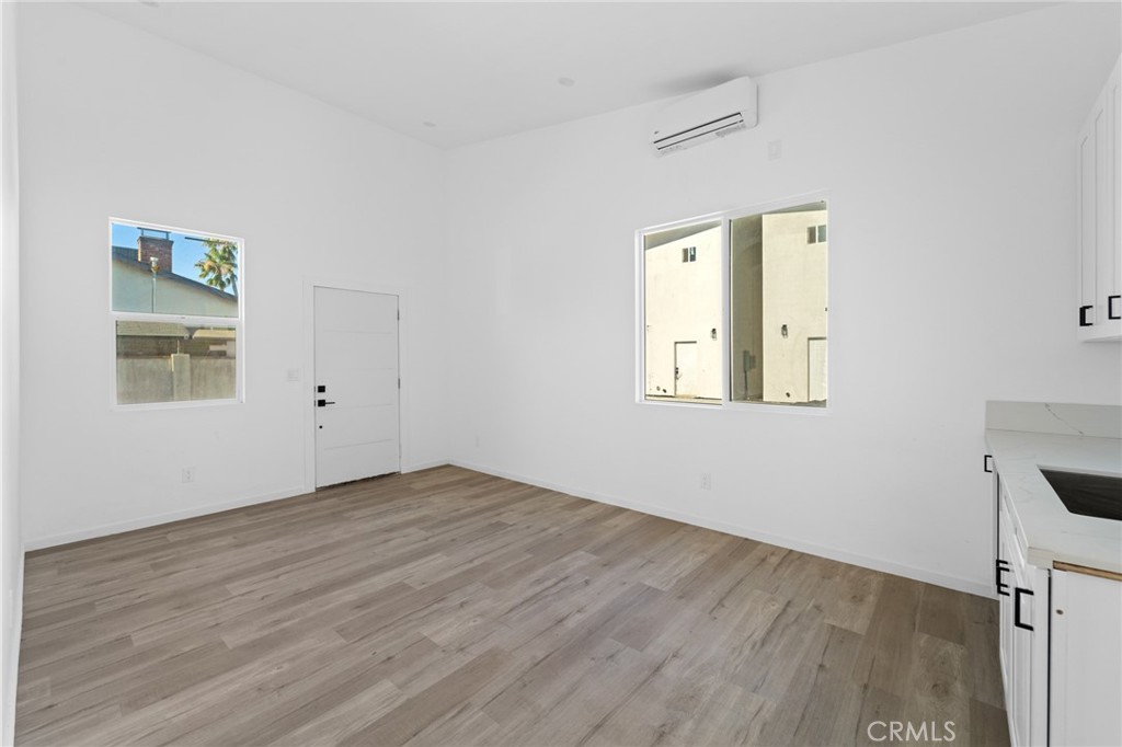 8510 1/2 Wilbur Avenue Northridge, CA 91324 - Photo 9 of 11 an empty room with wooden floor and windows